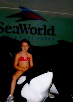 A picture of me on Shamu when I was a little kid at Sea World.